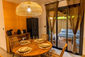 a dining room with a wooden table and chairs at Les Clos de L Albatros in Saint-Paul