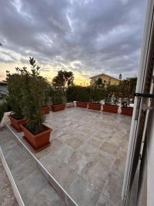 a patio with potted plants on it with the sunset at Casa della Cittadella in Noto +9 photos