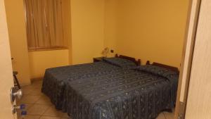a bedroom with a bed with a blue comforter at Albergo Coira Antica Dimora in Santa Brigida