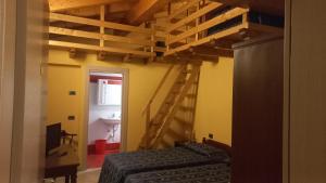 a room with a bed and a staircase and a bathroom at Albergo Coira Antica Dimora in Santa Brigida