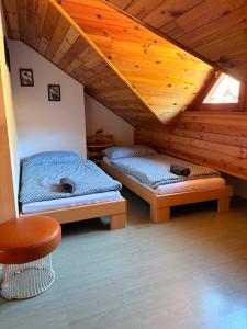 a room with two beds in a attic at Penzion u Zdichynců in Kubova Huť
