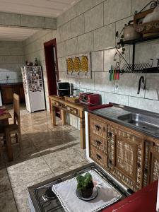 a kitchen with a sink and a refrigerator at Quartos em Tiradentes MG - A Casa Sarará in Tiradentes