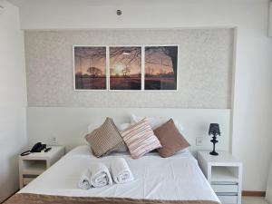 a white bed with three windows in a bedroom at Flat Confortável para Família ou a Trabalho, ao lado dos Ministérios e ESPLANADA, grande, completo, academia e no centro da cidade, em Saint Moritz Brasília Hotel in Brasília +41 photos