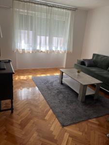 a living room with a green couch and a coffee table at Apartment Bedem Center in Bihać
