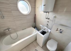 a bathroom with a tub and a toilet and a sink at Boreti Apartment in Budva +19 photos