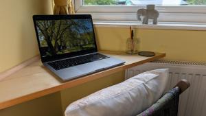 a laptop computer sitting on a desk next to a window at Hot Tub Home - Stay in Stoke on Trent