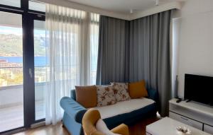 a living room with a couch and a large window at Boreti Apartment in Budva