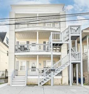 a white building with stairs on the side of it at Beach Block Ocean Views steps from the boardwalk in Ocean City