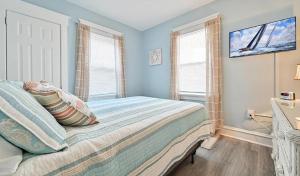 a bedroom with a bed with pillows on it at Beach Block Ocean Views steps from the boardwalk in Ocean City