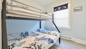 a bedroom with two bunk beds and a window at Beach Block Ocean Views steps from the boardwalk in Ocean City