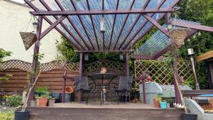 a pergola with a table and chairs on a patio at Hot Tub Home - Stay in Stoke on Trent