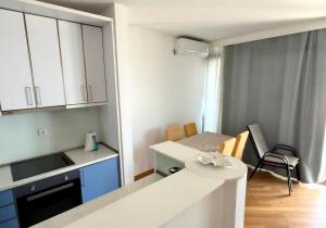 a small white kitchen with a table and a counter at Boreti Apartment in Budva
