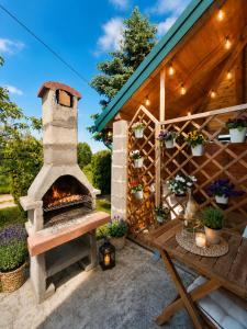 a patio with a pizza oven next to a building at Guesthouse Mreznica- Mreznicka Idila resort in Galović-Selo