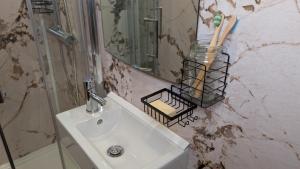 a bathroom with a sink and a mirror at Hot Tub Home - Stay in Stoke on Trent +20 photos