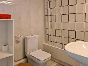 a white bathroom with a toilet and a sink at Elenas sweet home - Penthouse with Large Balcony in Pyrgos +34 photos