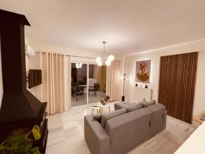 a living room with a couch and a table at Elenas sweet home - Penthouse with Large Balcony in Pyrgos