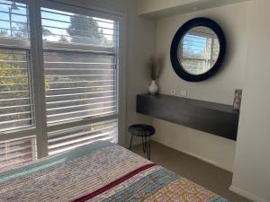 a bedroom with a bed and a mirror on the wall at Huntlee Getaway in Branxton