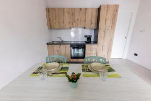 a dining room with a table and chairs and a kitchen at Acochì in Roccasparvera