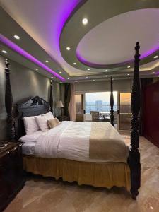 a bedroom with a large bed with a purple ceiling at Nile Royale Hotel in Cairo