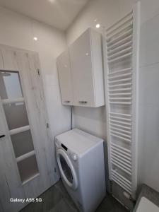 a small bathroom with a washing machine in it at Lomnica Lodge in Vysoké Tatry