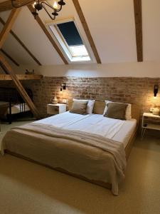 a bedroom with a large bed with a brick wall at TimHouse in Timişoara
