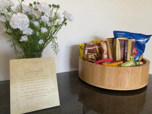 a wooden bowl filled with snacks and a vase of flowers at Huntlee Getaway in Branxton