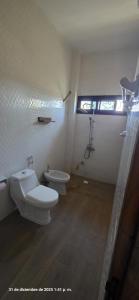 a bathroom with two toilets and a window at Tata Khane in Ngaring +15 photos