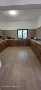 an empty room with a large kitchen with wooden floors at Tata Khane in Ngaring