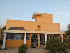 a yellow building with a door with grids on it at Tata Khane in Ngaring
