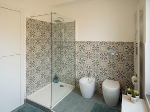 a bathroom with a shower and a tub and a toilet at Testa tra le Nuvole - Attico con Terrazza panoramica in centro in Novi Ligure +9 photos