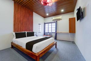 a bedroom with a large bed in a room at Super Hotel O AM Grandd in Kāraikkudi