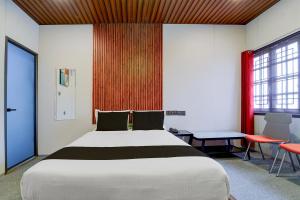 a bedroom with a large bed and a table and chairs at Super Hotel O AM Grandd in Kāraikkudi