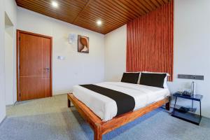 a bedroom with a large bed and a wooden door at Super Hotel O AM Grandd in Kāraikkudi