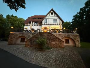 a building with a stone wall in front of it at Attikos Hotel & Restaurant in Lengenfeld