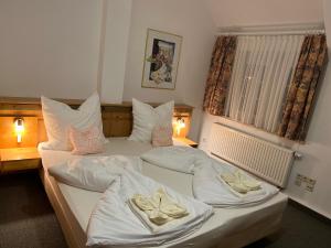 a bedroom with two beds with white sheets and pillows at Attikos Hotel & Restaurant in Lengenfeld +35 photos