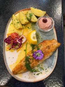 a plate of food with fish and vegetables on a table at Attikos Hotel & Restaurant in Lengenfeld