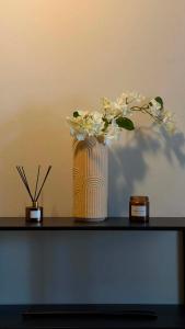 a vase with flowers sitting on a table at Charming room central Oslo in Oslo +5 photos
