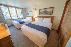 a bedroom with two beds and two windows at Pines 2147 by SummitCove Lodging in Colorado in Keystone