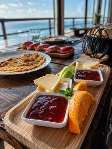 a wooden table topped with different types of cheese and jam at Hotel Kappa3 Villas in Vlorë +77 photos