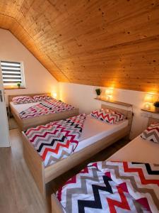 three beds in a room with wooden ceilings at Guesthouse Mreznica- Mreznicka Idila resort in Galović-Selo +39 photos