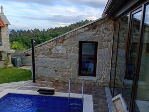 a house with a swimming pool next to a building at Casa rústica busto in Armentera
