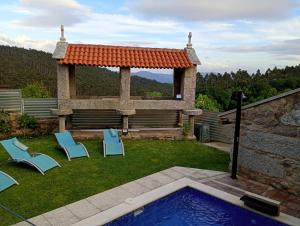 a backyard with a gazebo and chairs and a pool at Casa rústica busto in Armentera