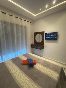 a bedroom with a bed and a tv on the wall at Mehdia plage in Kenitra