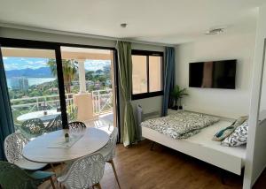 a room with a bed and a table and a balcony at Splendid view Apartment in Cannes in Cannes