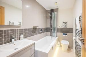 a white bathroom with a sink and a toilet at Orange House, Southwold in Southwold +29 photos