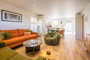 a living room with a couch and a table at Orange House, Southwold in Southwold