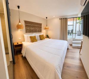 a bedroom with a large white bed and a window at Poblado Luum Boutique hotel in Medellín