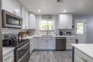 a kitchen with white cabinets and a sink at Chandler Galveston in Chandler