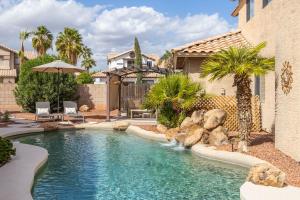 a swimming pool with a waterfall in a yard at Gilbert Douglas in Gilbert