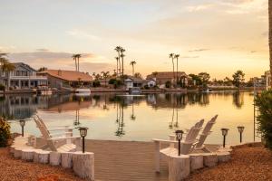 a group of chairs sitting on a dock next to a lake at Gilbert Willow Tree in Gilbert